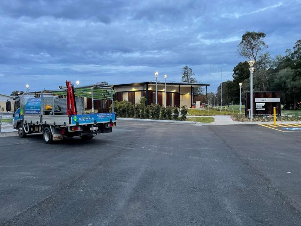 Two Trucks Are Parked In A Parking Lot In Front Of A Building — BayCoast Electrical & Control Solutions In South Durras, NSW