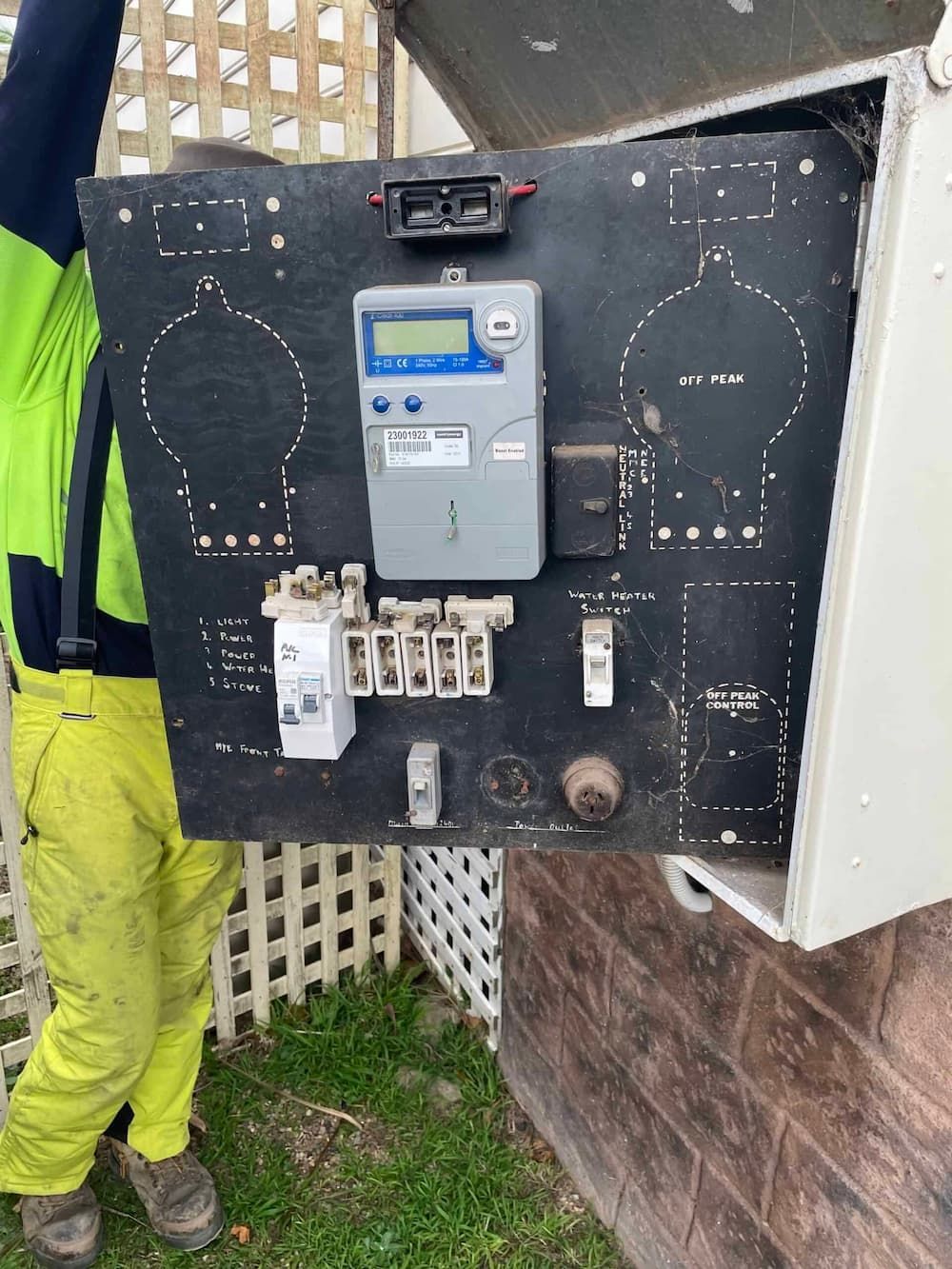 A Man Is Holding a Black Board with A Meter on It — Bay Coast Electrical & Control Solutions in Maloneys Beach, NSW