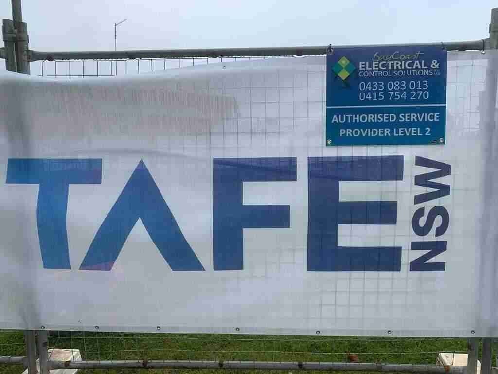 A Sign that Says Tafe Nsw Is Hanging on A Fence — Bay Coast Electrical & Control Solutions in Maloneys Beach, NSW