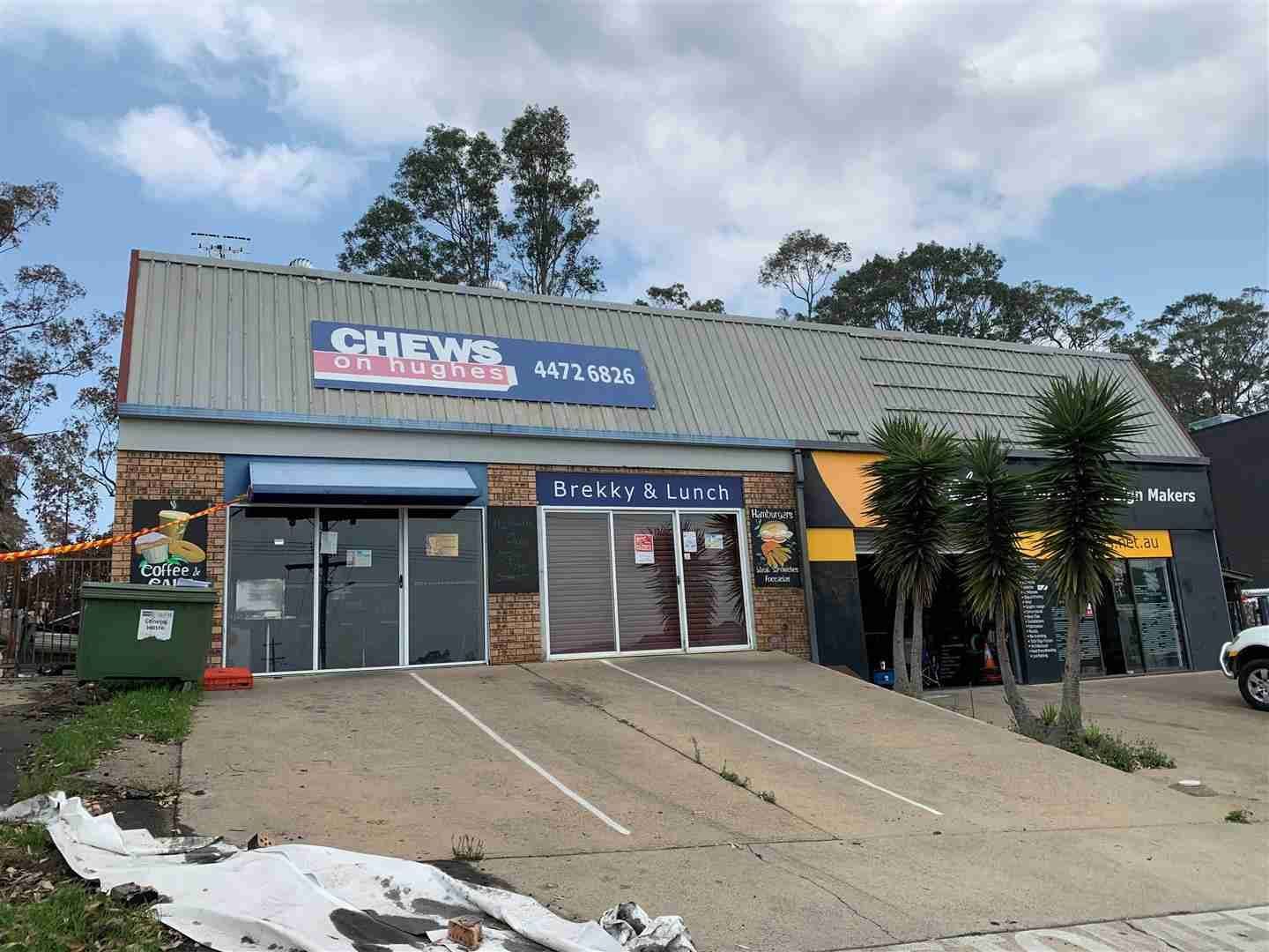 A Large Building with A Lot of Windows and A Sign on The Side of It — Bay Coast Electrical & Control Solutions in Maloneys Beach, NSW