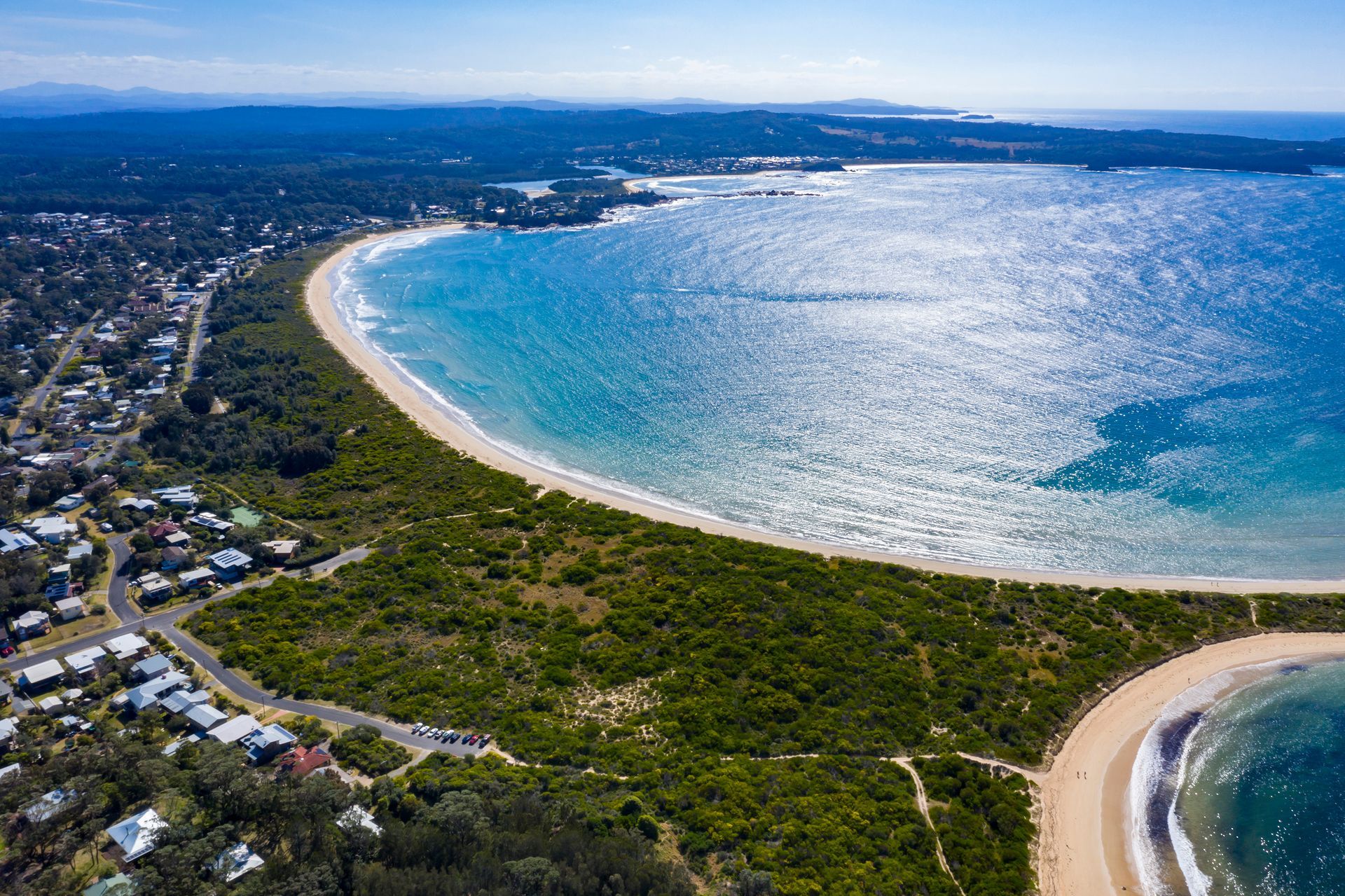 An Aerial View of a Beach Surrounded by Trees and a Body of Water — BayCoast Electrical & Control Solutions In Broulee, NSW