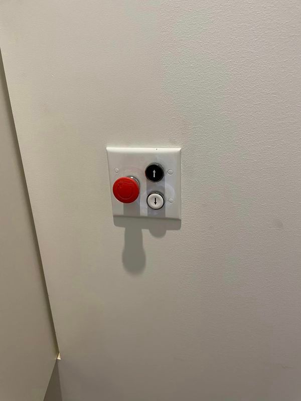 A White Wall with A Red Button on It — Bay Coast Electrical & Control Solutions in Maloneys Beach, NSW