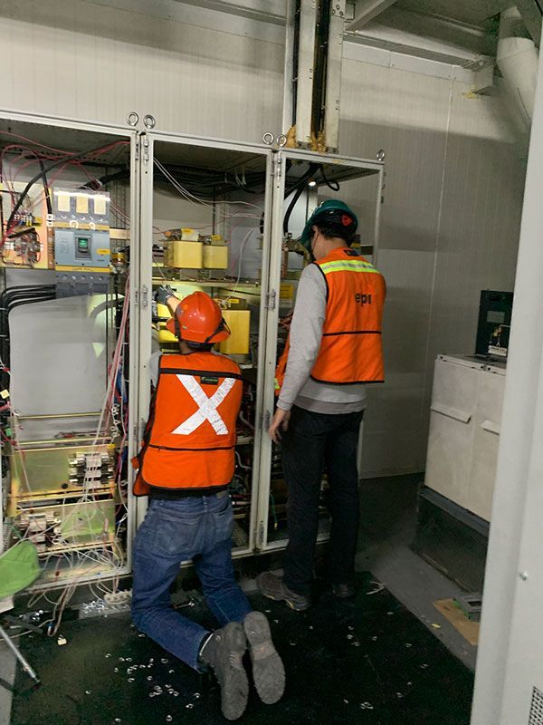 Dos hombres con chalecos naranjas con la letra x