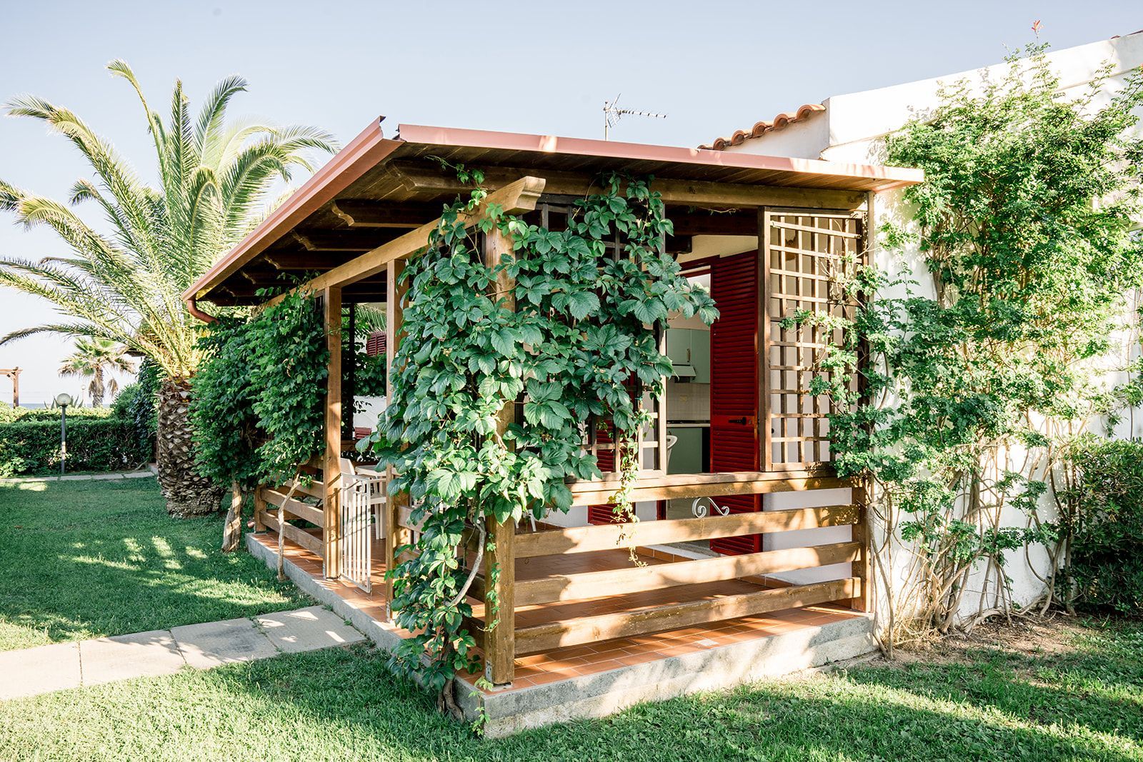 Tavolo del ristorante apparecchiato con bicchieri e vista dalla finestra, un quadro con tre vecchie foto sulla parete.