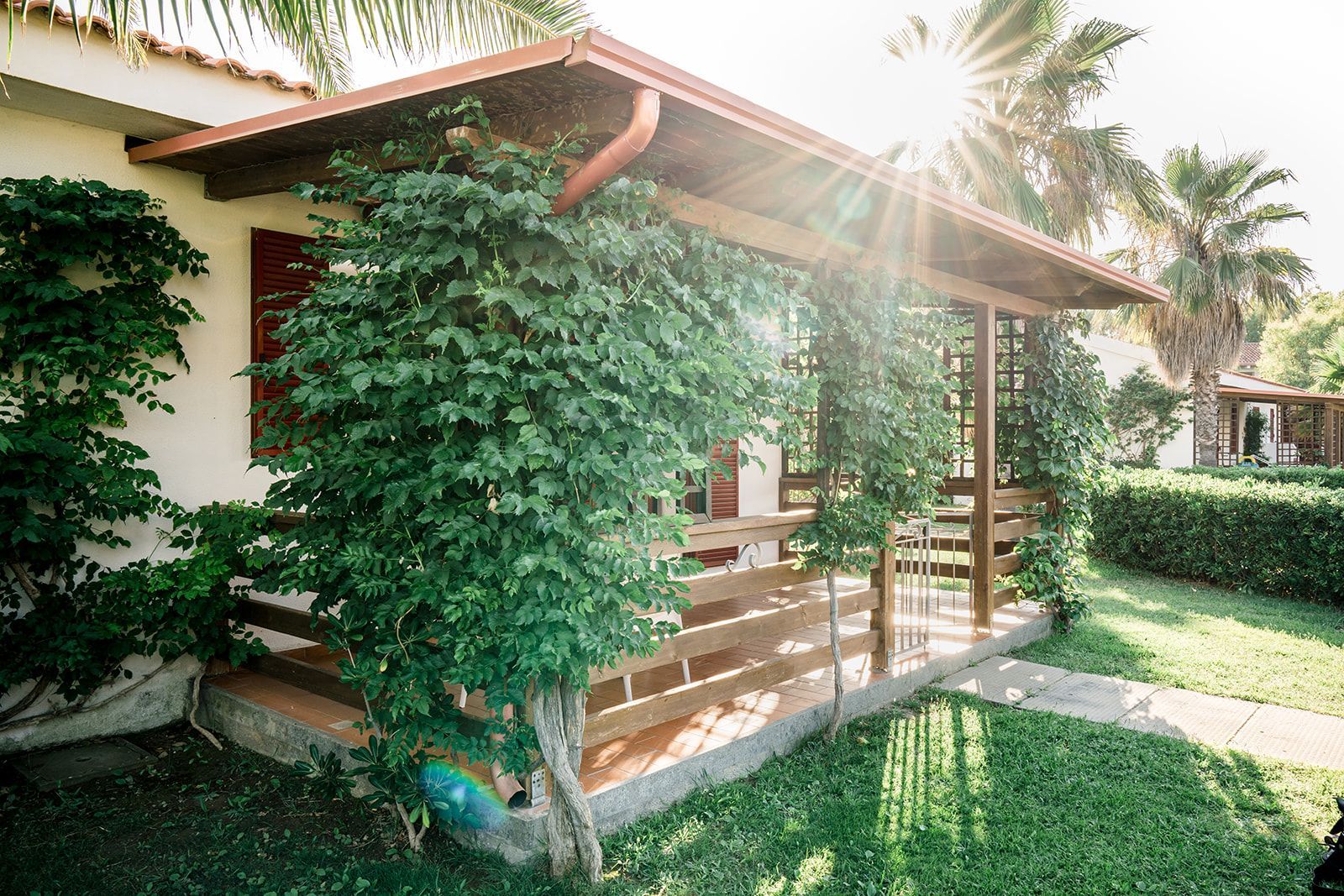 Lo chef in camice bianco e grembiule a righe sorride, seduto fuori.