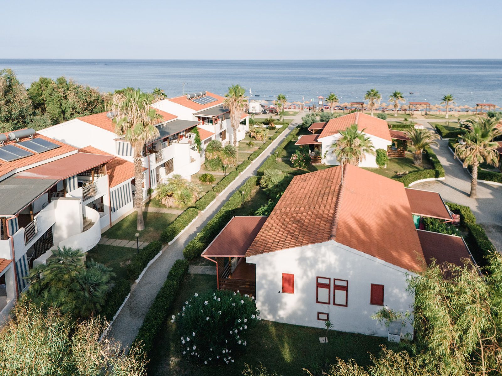 Tavolo del ristorante apparecchiato con bicchieri e vista dalla finestra, un quadro con tre vecchie foto sulla parete.