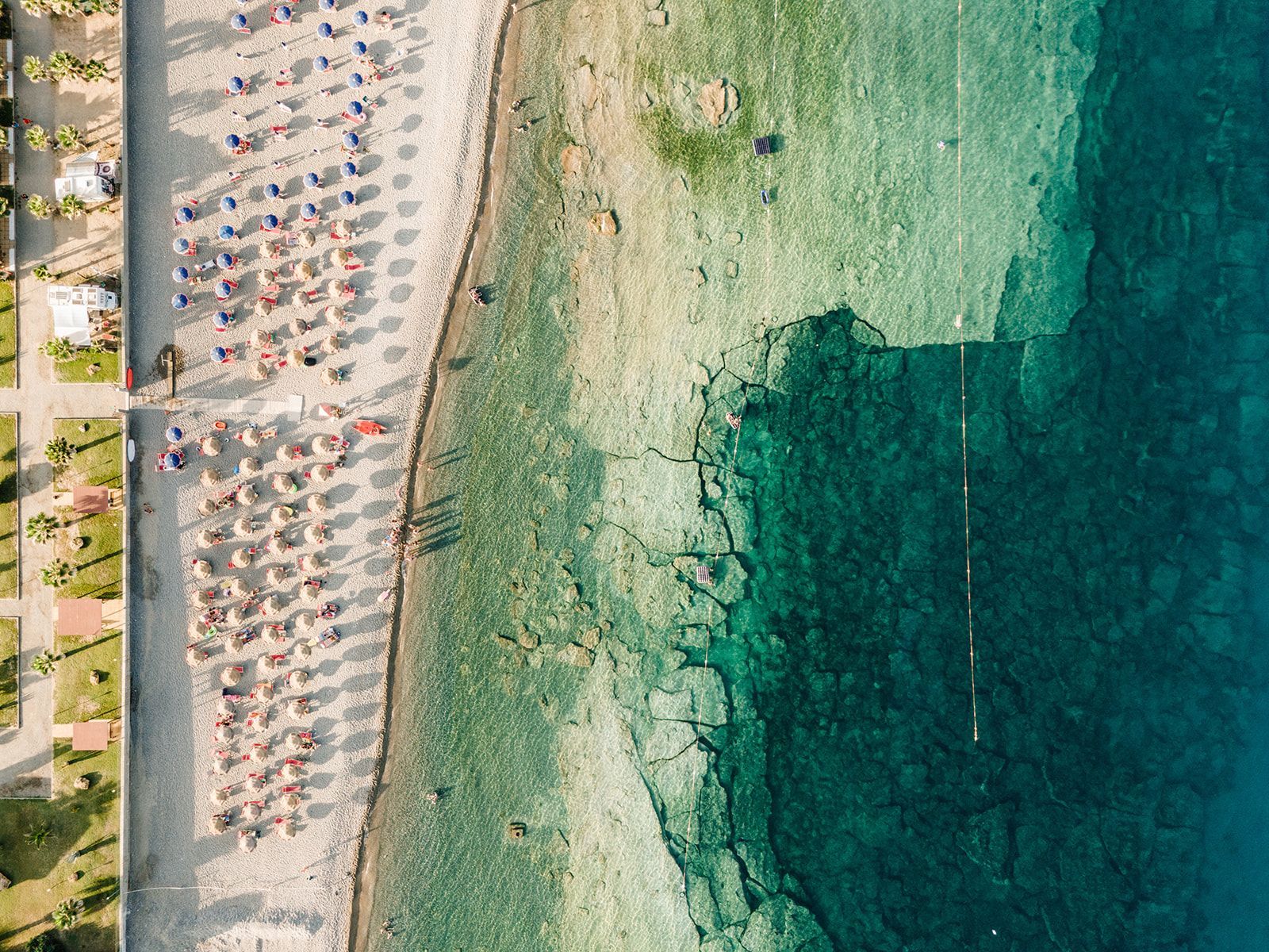 Tavolo del ristorante apparecchiato con bicchieri e vista dalla finestra, un quadro con tre vecchie foto sulla parete.