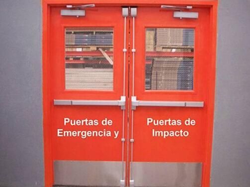 A red door that says puertas de emergencia y puertas de impacto