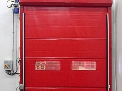 Una puerta de garaje roja con dos ventanas.