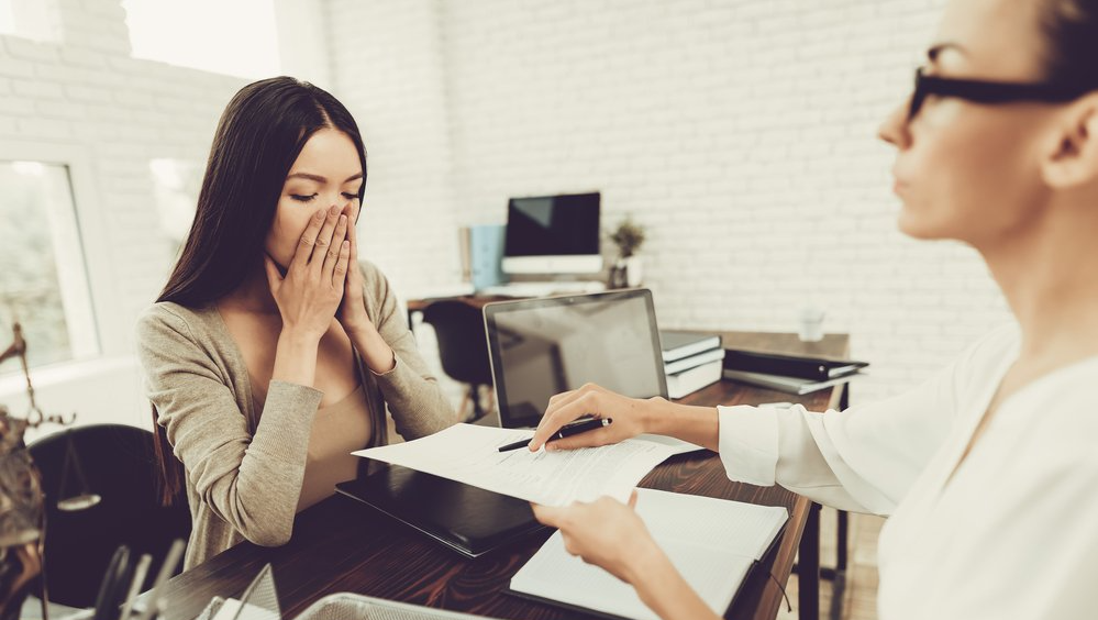 An anxious woman about to sign a separation agreement