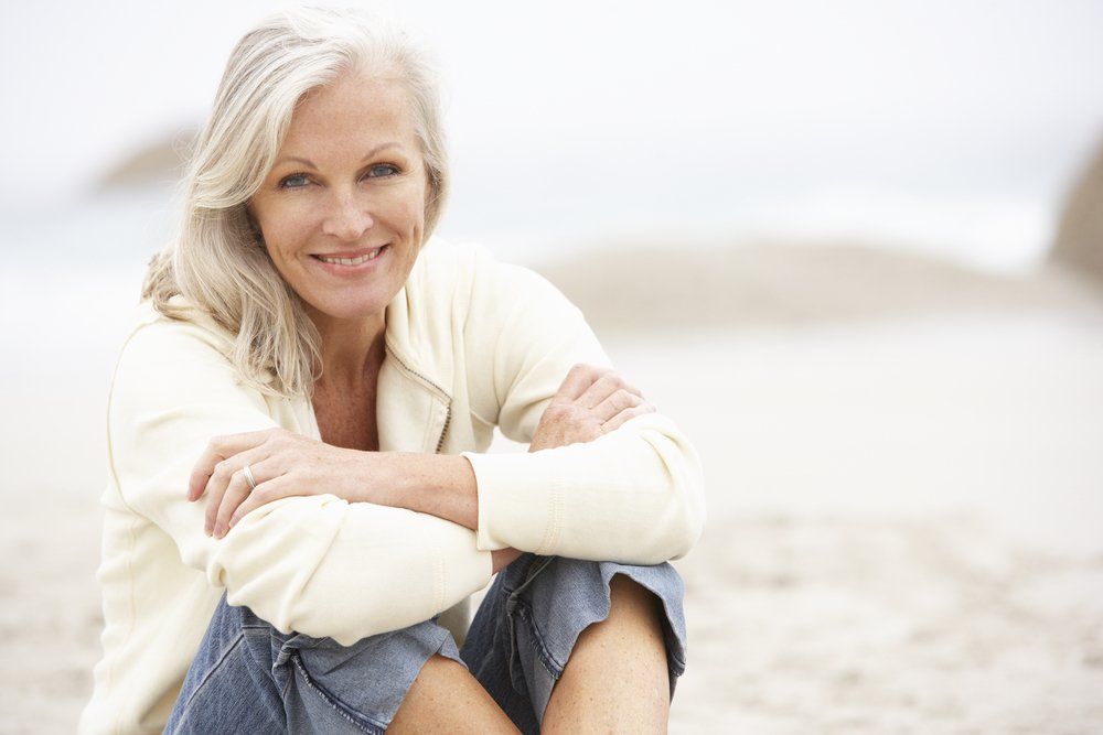 Elderly woman on beach after divorce retirement plan completed