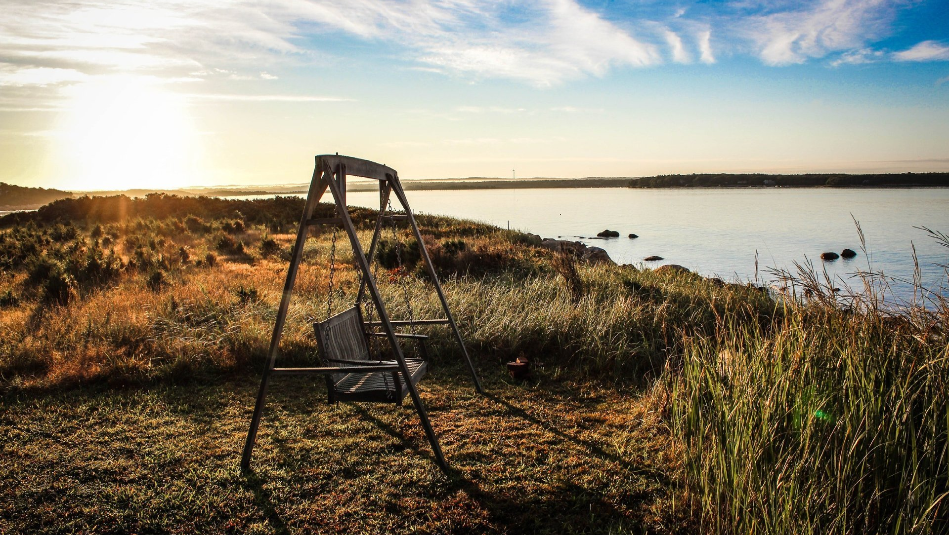 Wooden swing next to an ocean inlet