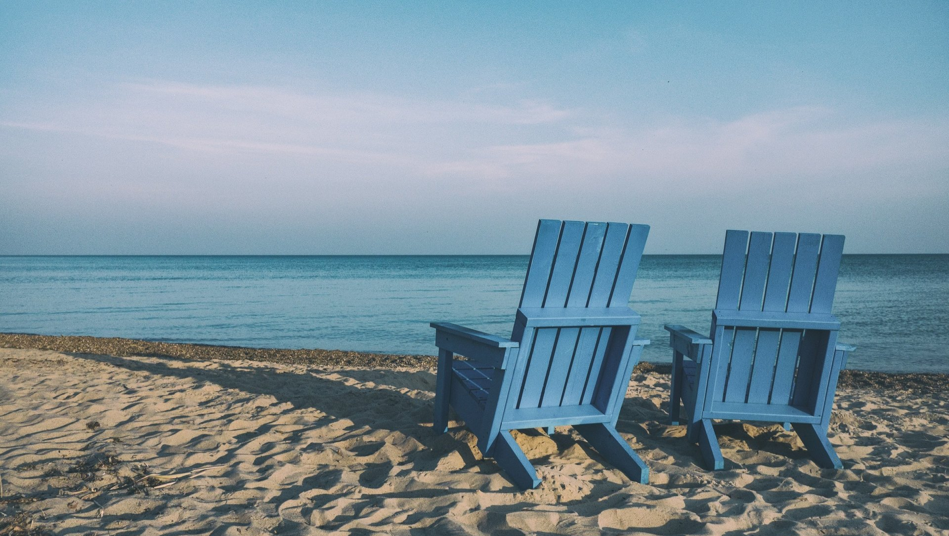 two blue beach chairs on the beach