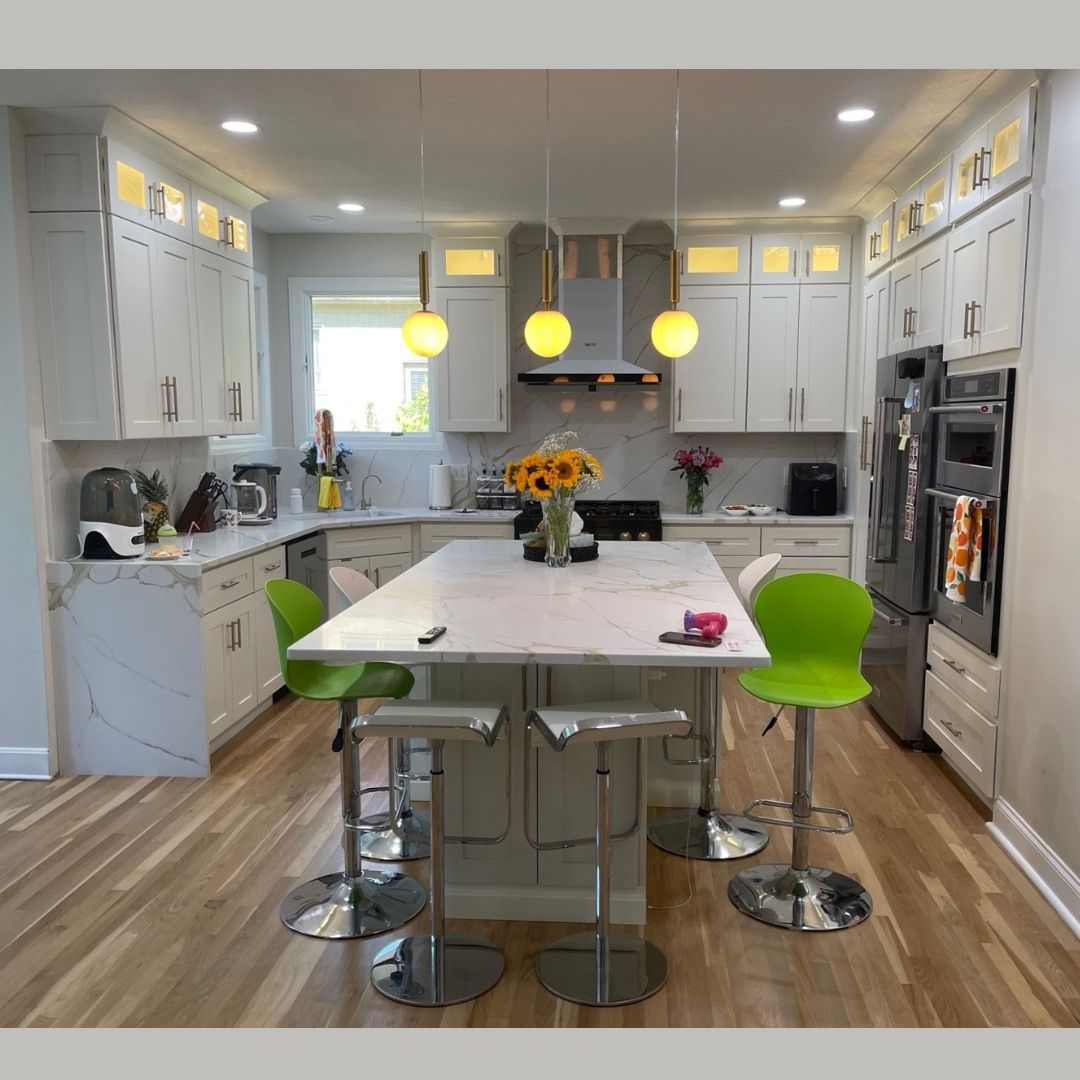 A kitchen with white cabinets and green stools
