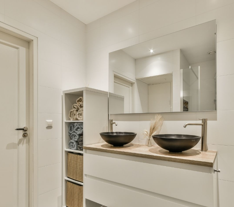 A bathroom with two sinks and a large mirror