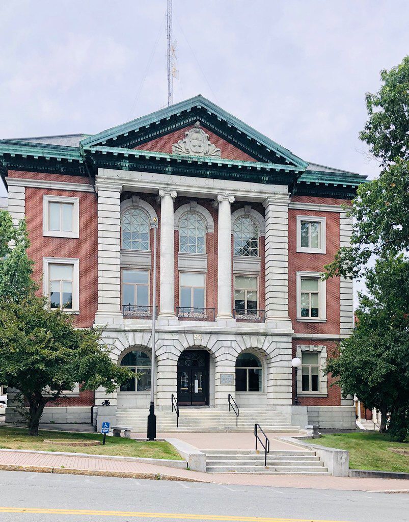 A large brick building with columns and a green roof