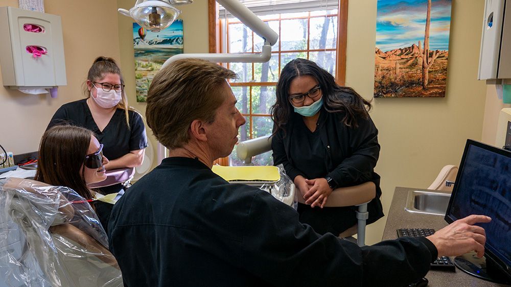 A dentist is working on a patient 's teeth in a dental office.