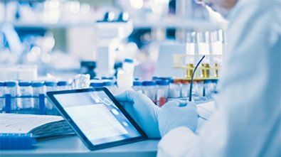 a scientist is using a tablet computer in a laboratory .