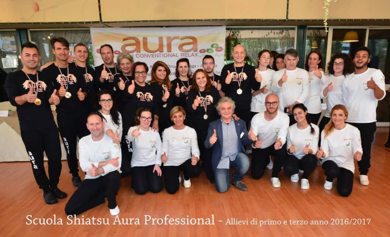 Un gruppo di persone in posa per una foto con la scritta aura professional in basso
