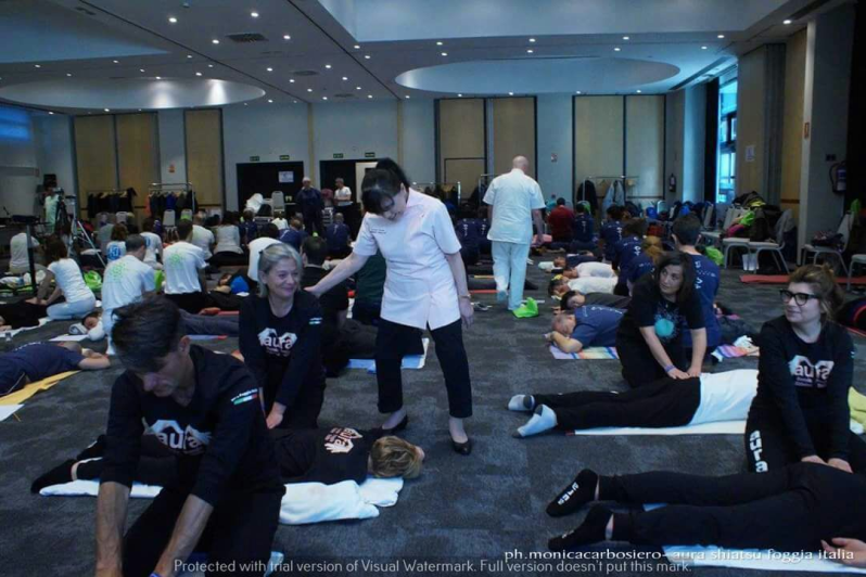 Un gruppo di persone è sdraiato sul pavimento in una grande stanza.