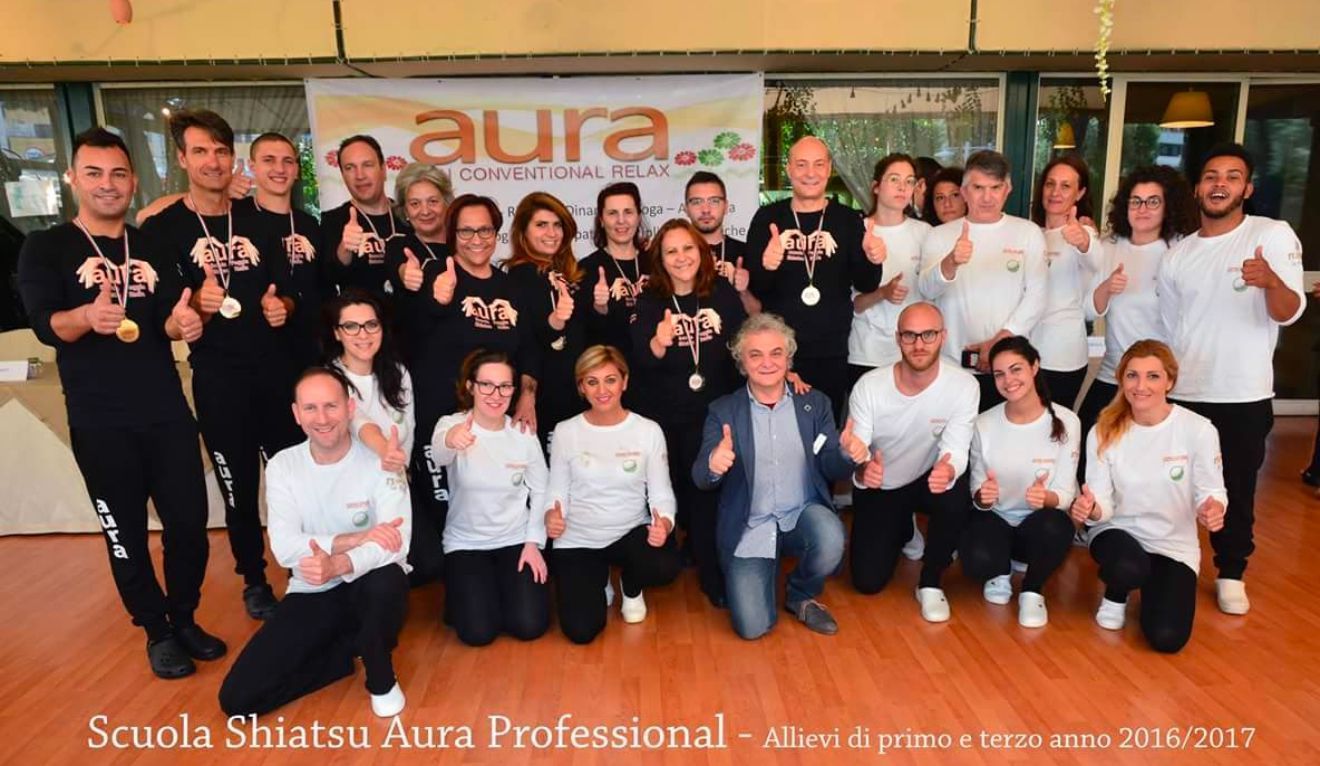 Un gruppo di persone in posa per una foto con la parola aura sullo sfondo