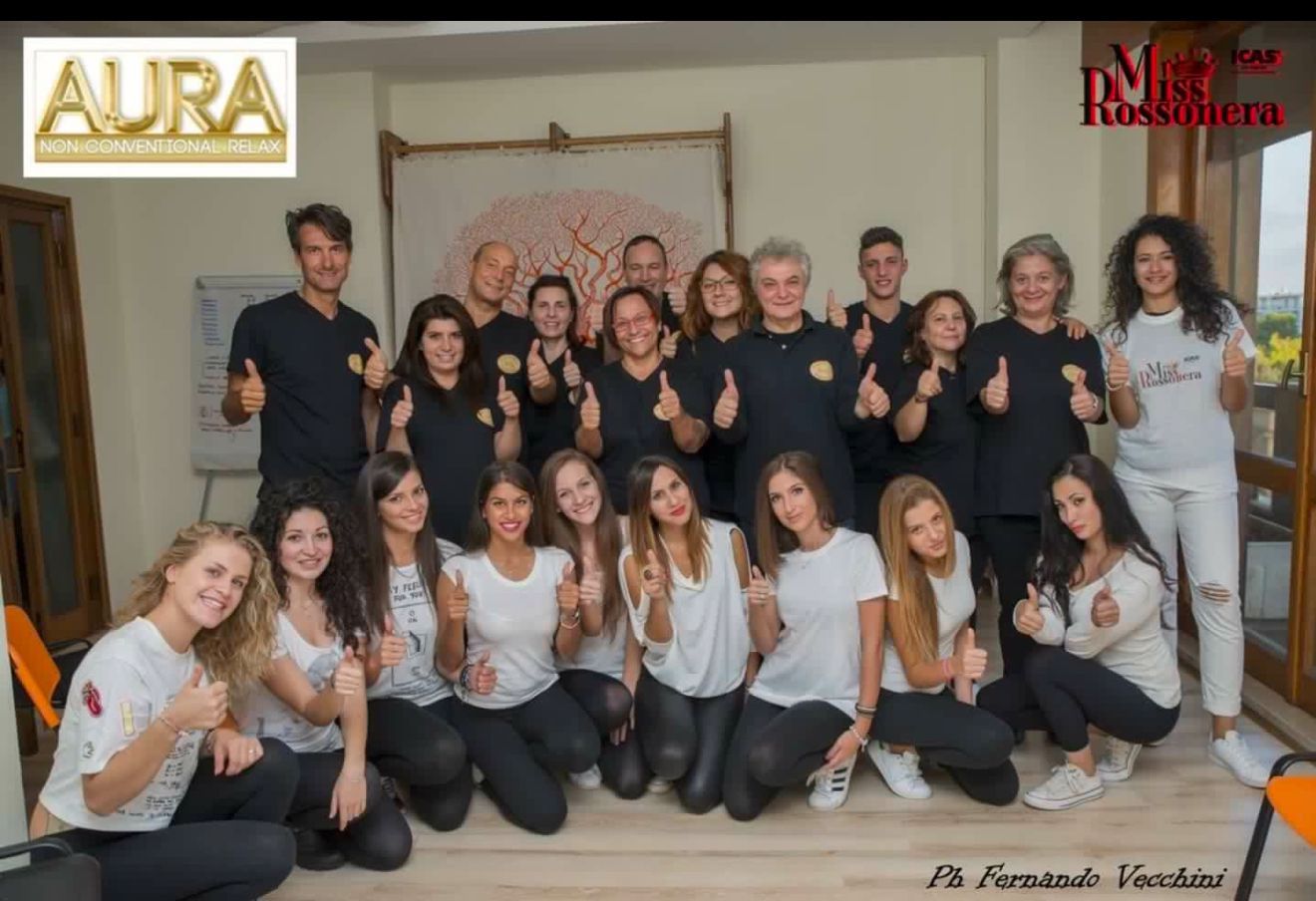 Un gruppo di persone in posa per una foto con la scritta aura in basso