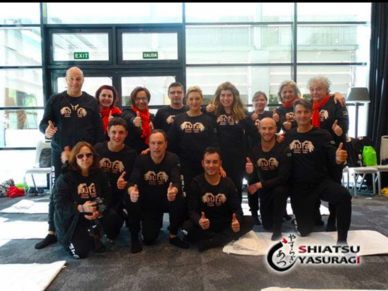 Un gruppo di persone in posa per una foto con la scritta shiatsu in basso