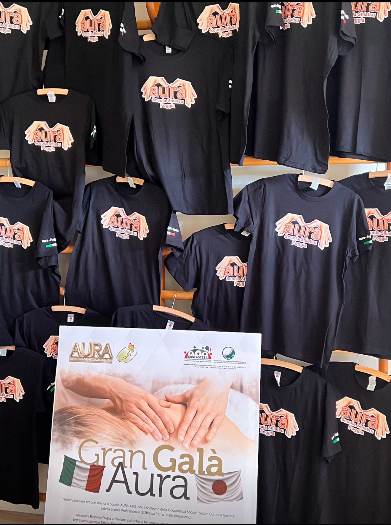 Un gruppo di camicie nere sono appese a un muro con un cartello che dice gran gala aura