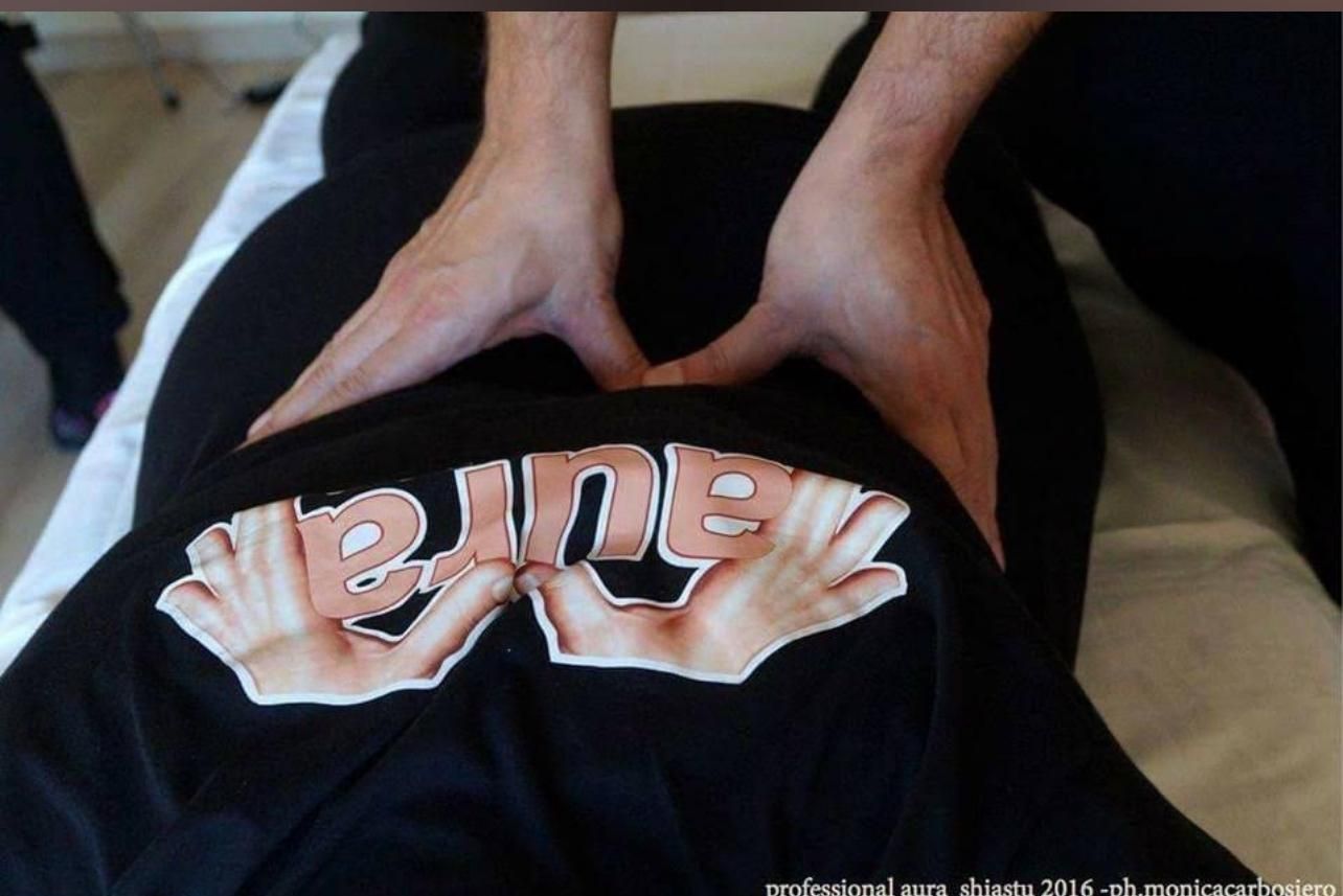 Una persona riceve un massaggio da qualcuno che indossa una maglietta con la scritta pino