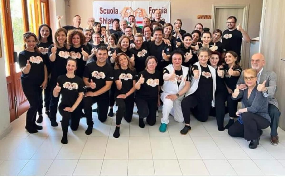 Un folto gruppo di persone posa per una foto.