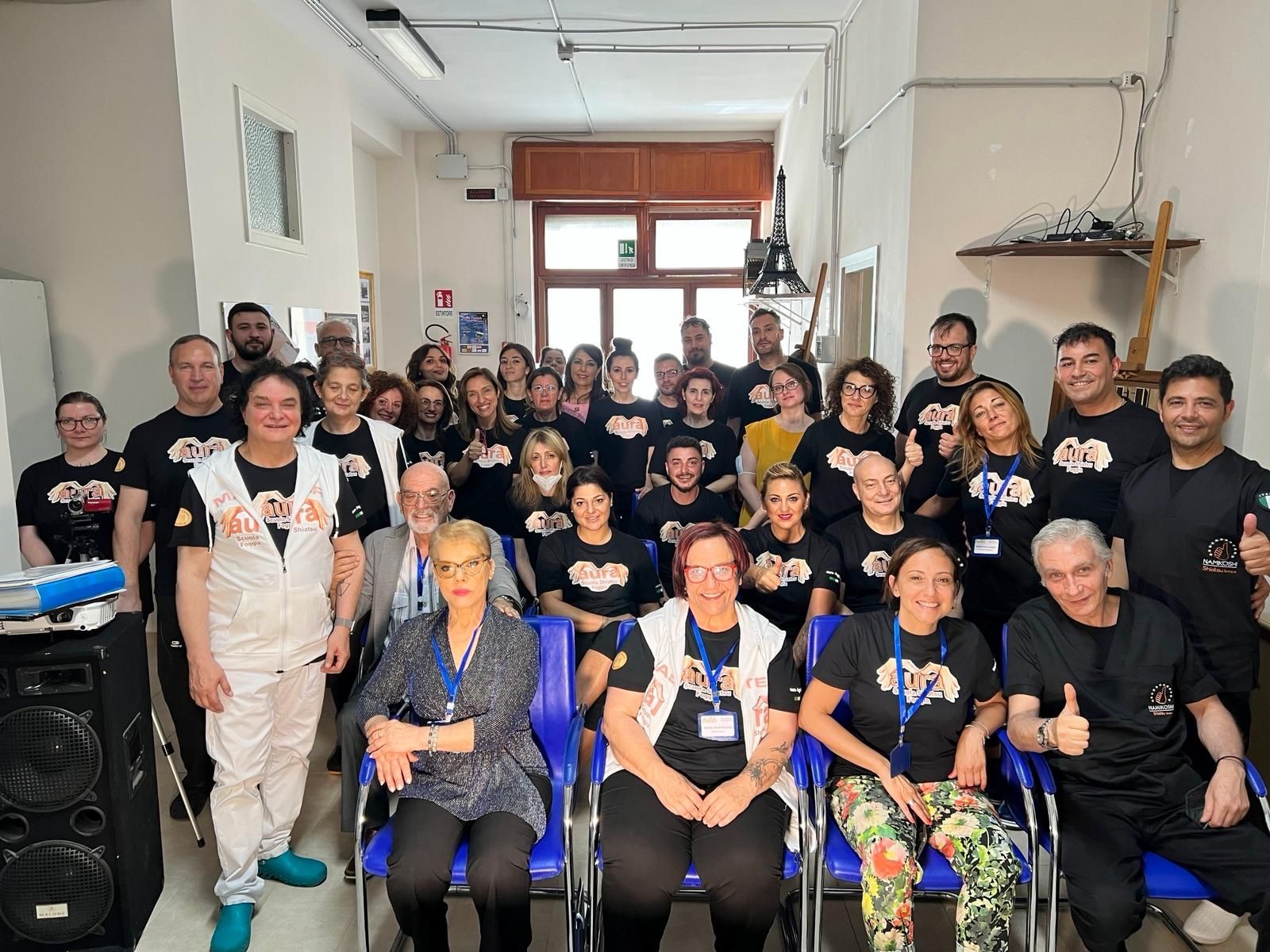 Un folto gruppo di persone posa per una foto in una stanza.