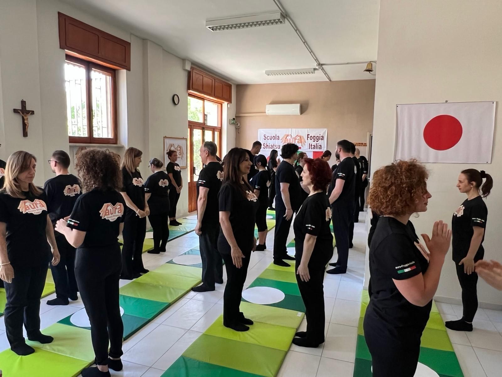 Un gruppo di persone è in piedi in una stanza con una bandiera sul muro.