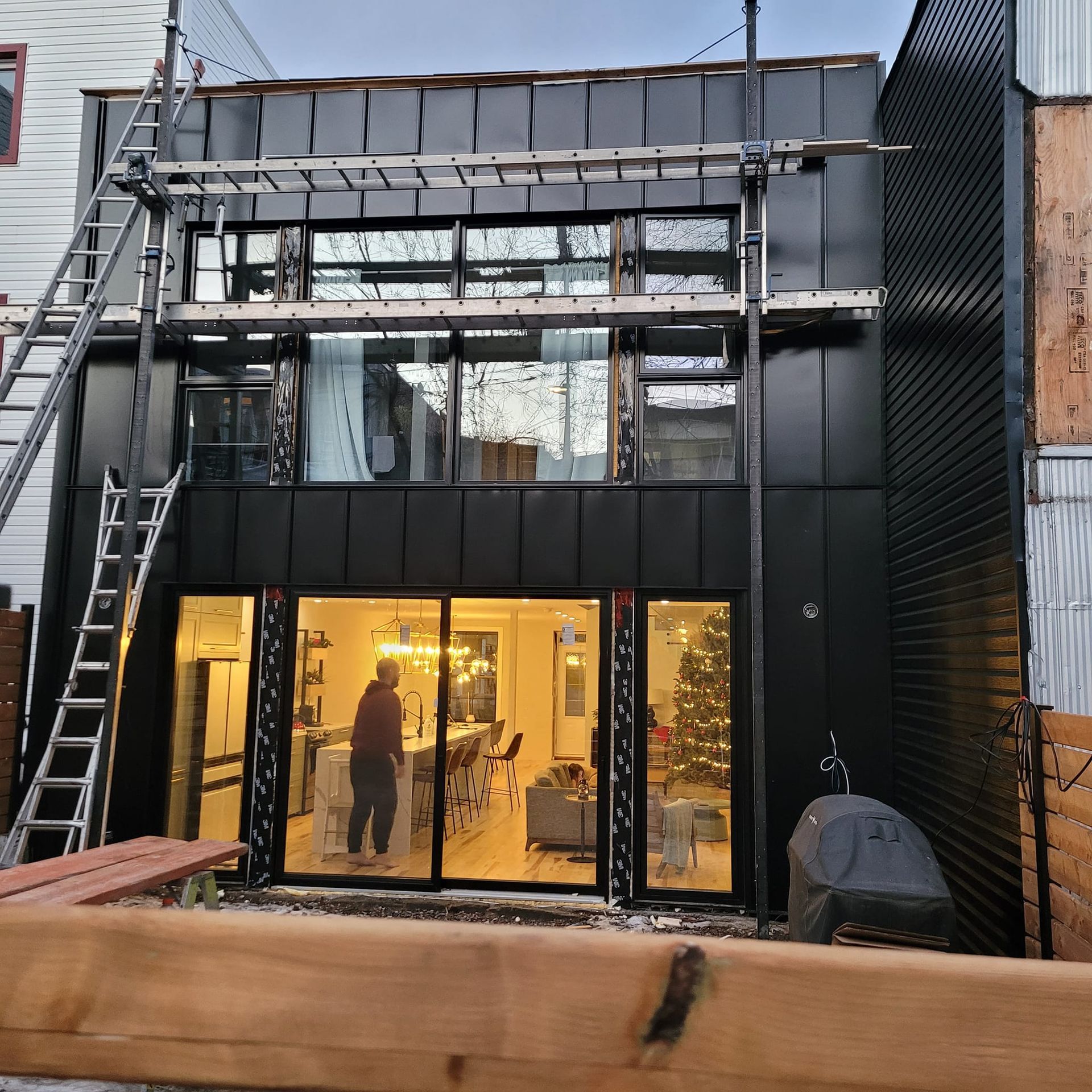 Un bâtiment noir avec beaucoup de fenêtres et une échelle