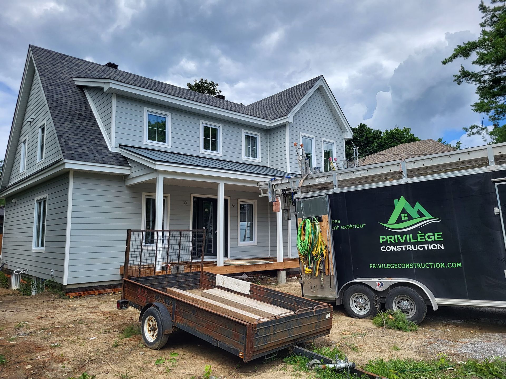 Une maison en construction avec une caravane garée devant.