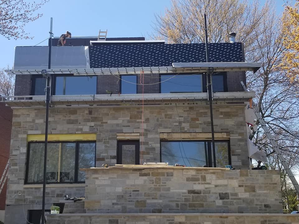 Un grand bâtiment en briques avec beaucoup de fenêtres et des panneaux solaires sur le toit