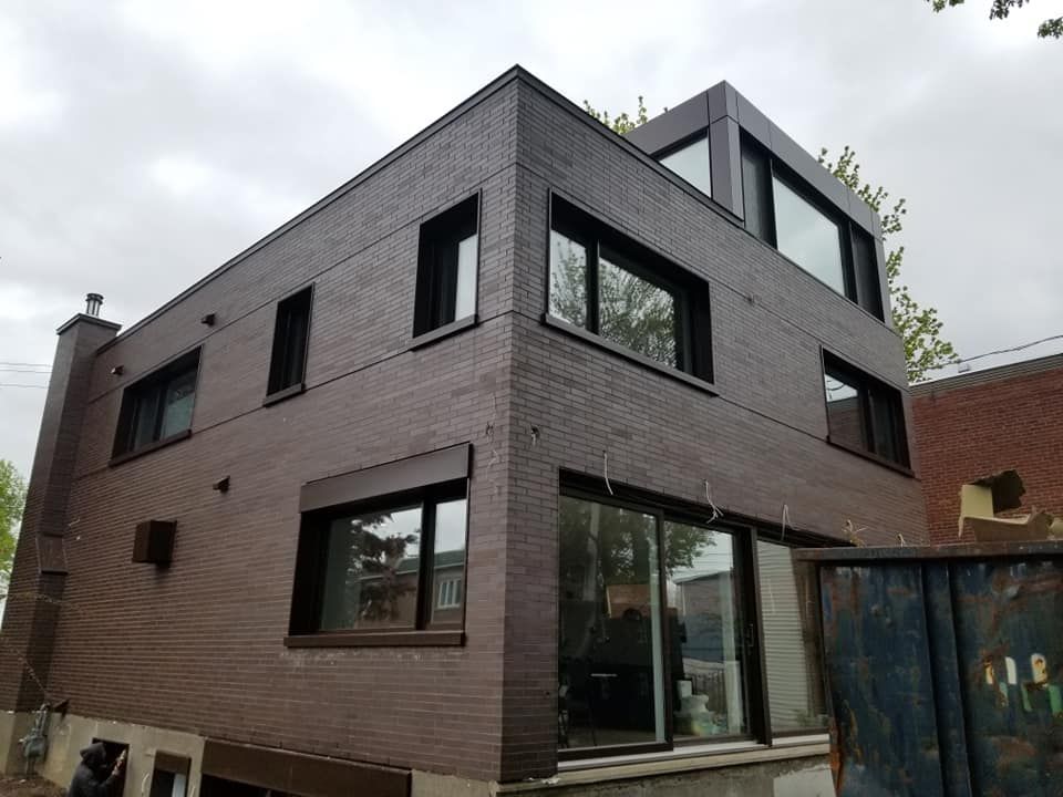Un grand bâtiment en briques brunes avec beaucoup de fenêtres