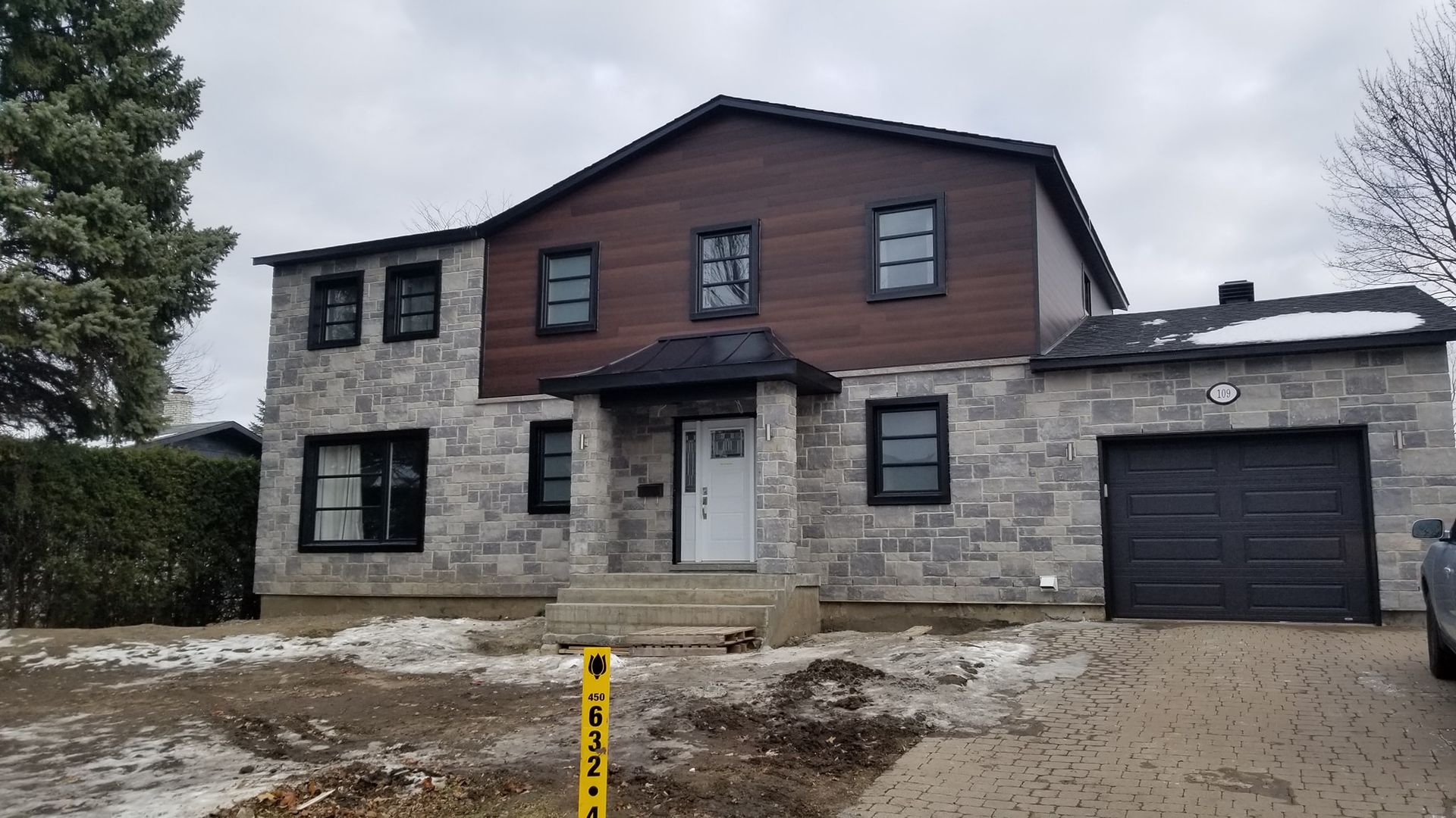 Une grande maison avec une voiture garée devant.