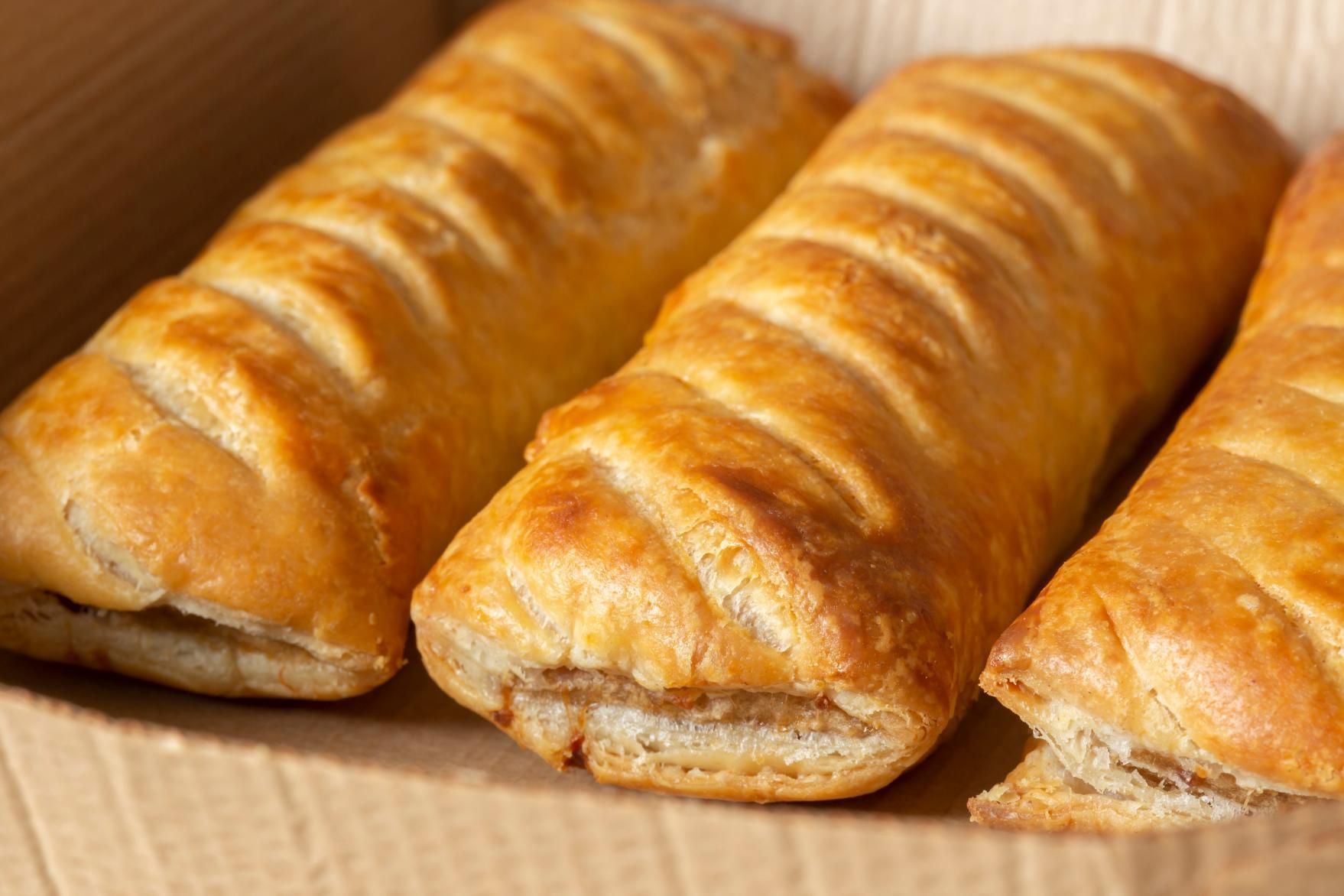 Three Sausage Rolls Are Sitting In A Cardboard Box — Edgeworth Meat & More in Edgeworth, NSW