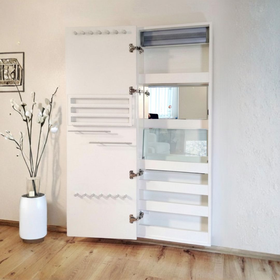 Persiana blanca con paneles de listones junto a un jarrón con ramas blancas en una habitación luminosa.