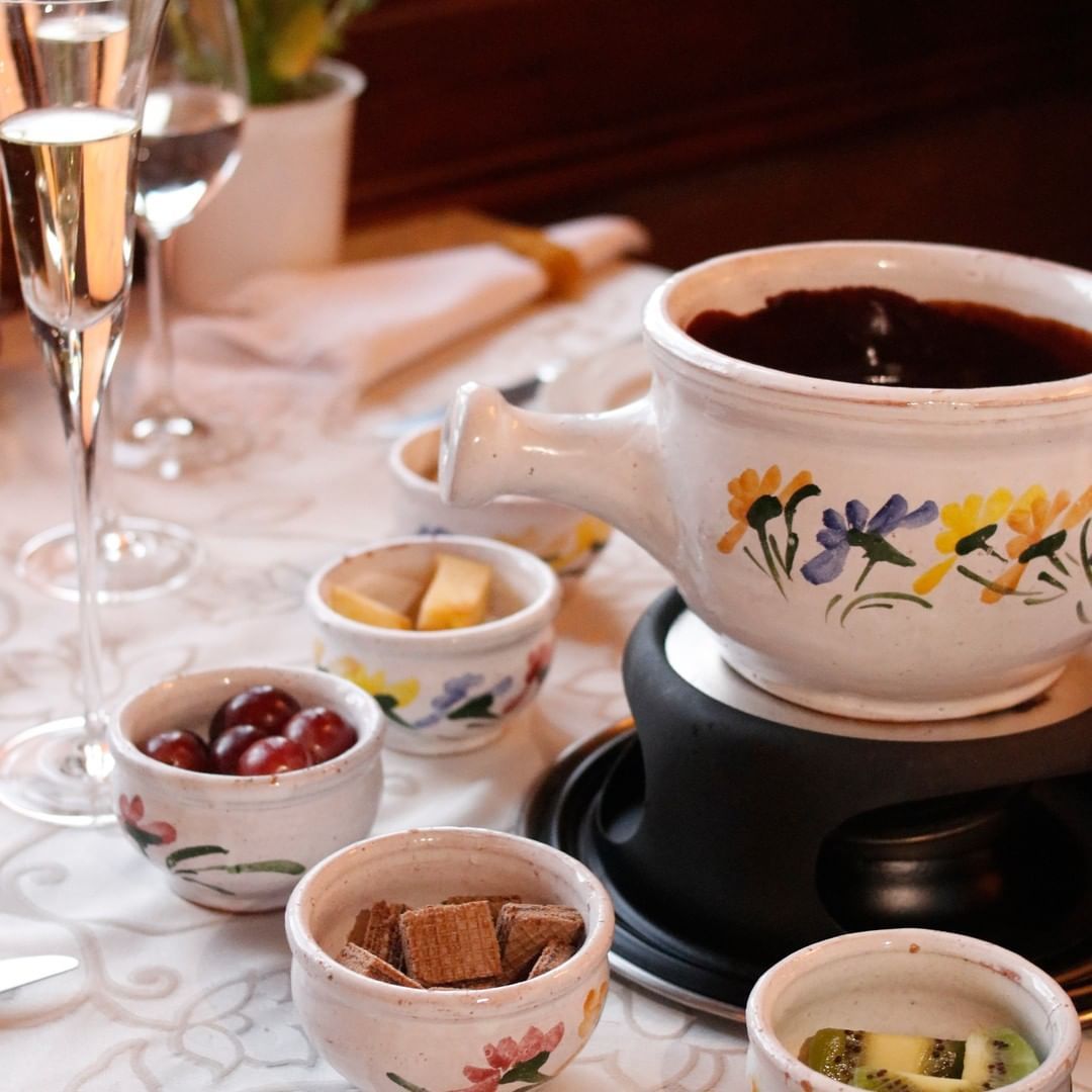Um vaso de fondue com flores sobre uma mesa