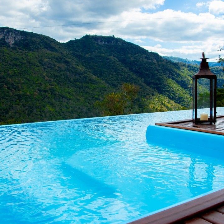 Uma piscina infinita com montanhas ao fundo