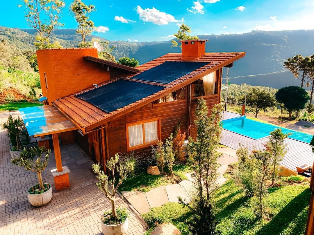 Uma vista aérea de uma casa de madeira com piscina no quintal.