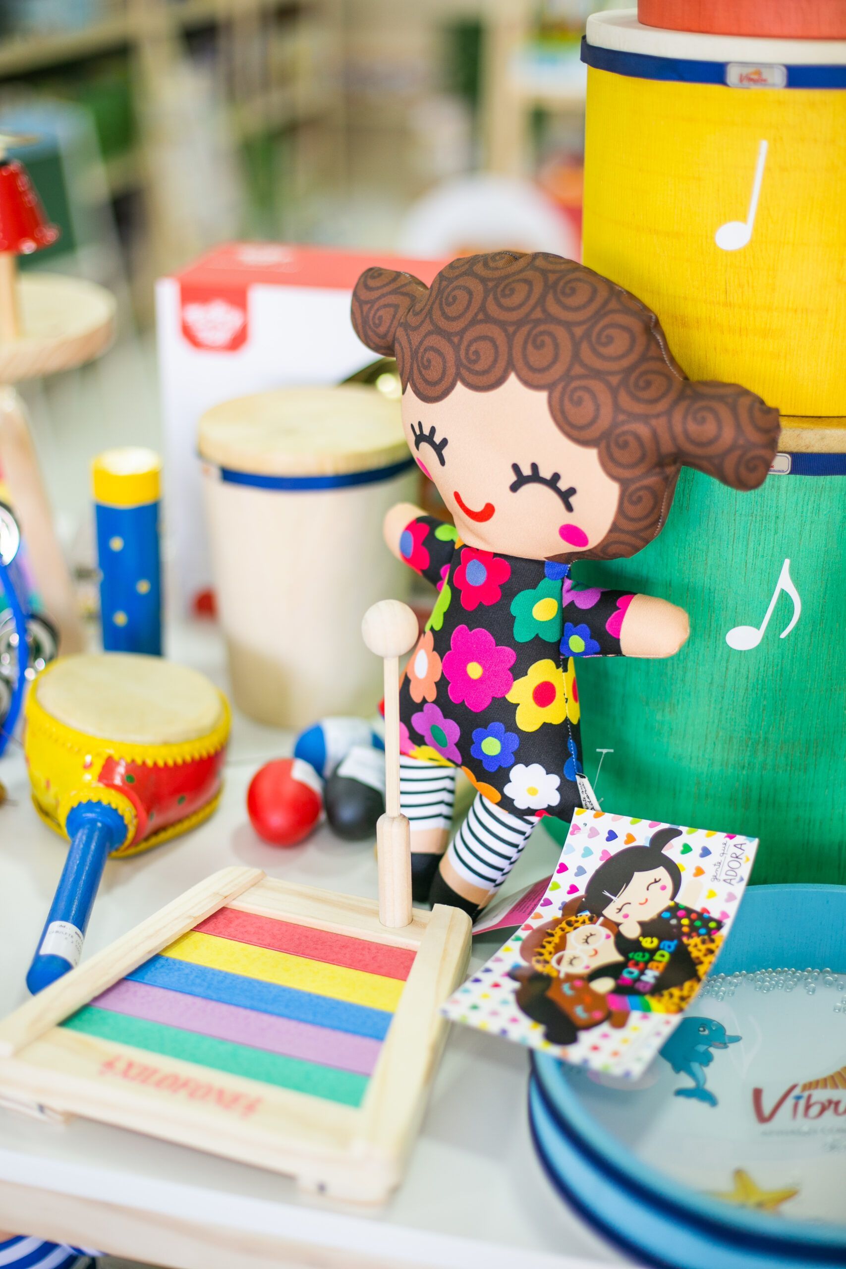 Uma boneca está sentada em cima de uma pilha de instrumentos musicais