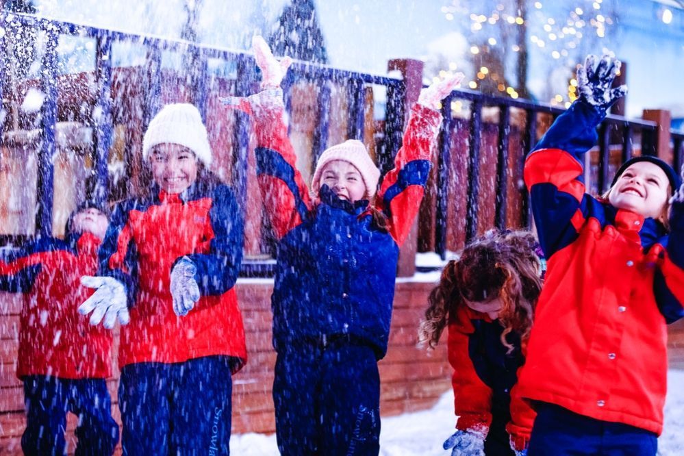 Um grupo de crianças está brincando na neve.