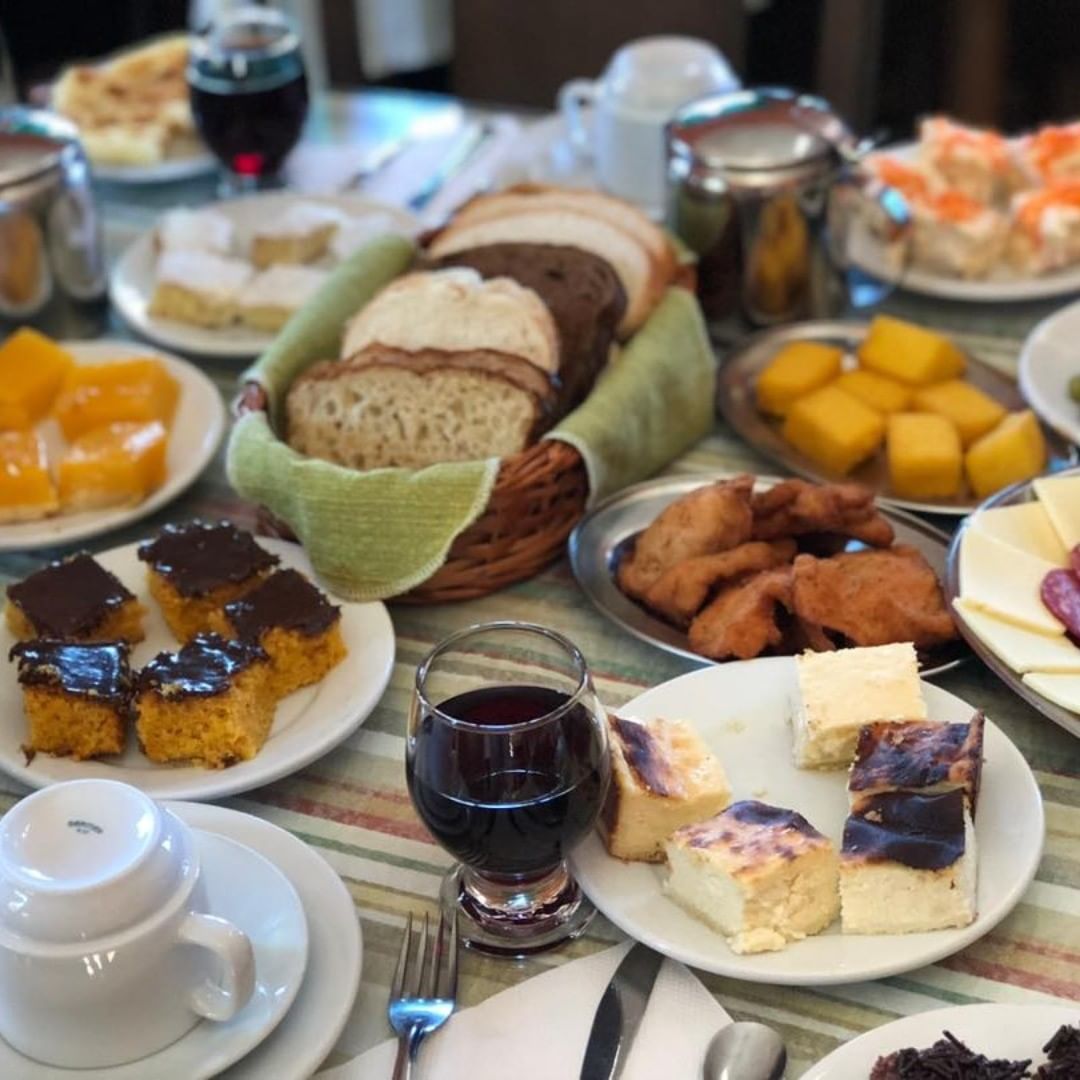 Uma mesa coberta com pratos de comida, incluindo uma cesta de pão