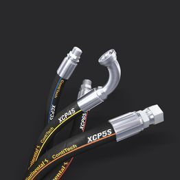 Un tas de tuyaux hydrauliques sont posés les uns sur les autres sur une surface noire.