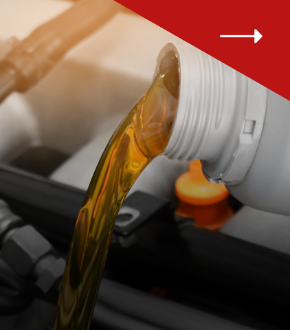 Golden motor oil pouring from a plastic bottle into a car engine.