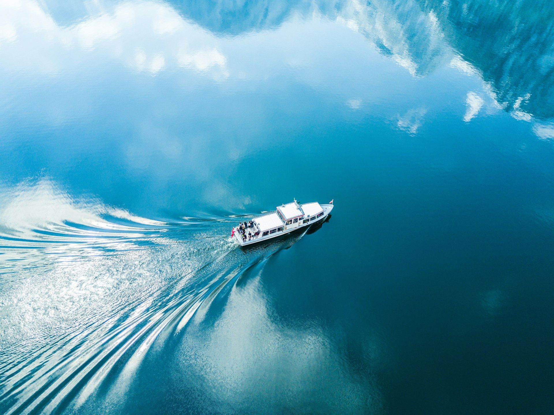 Aerial view of a motorboat cruising calm blue lake water, illustrating boat insurance for Wise Count