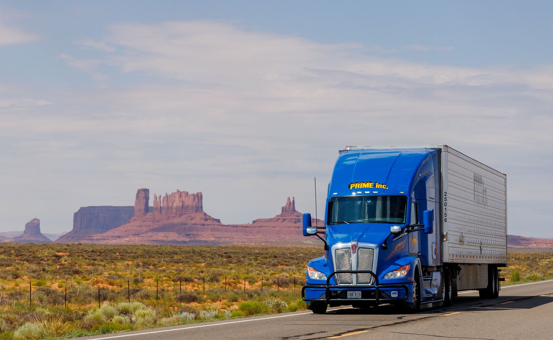 Blue semi-truck hauling a cargo trailer on a Texas highway, illustrating motor truck cargo insurance