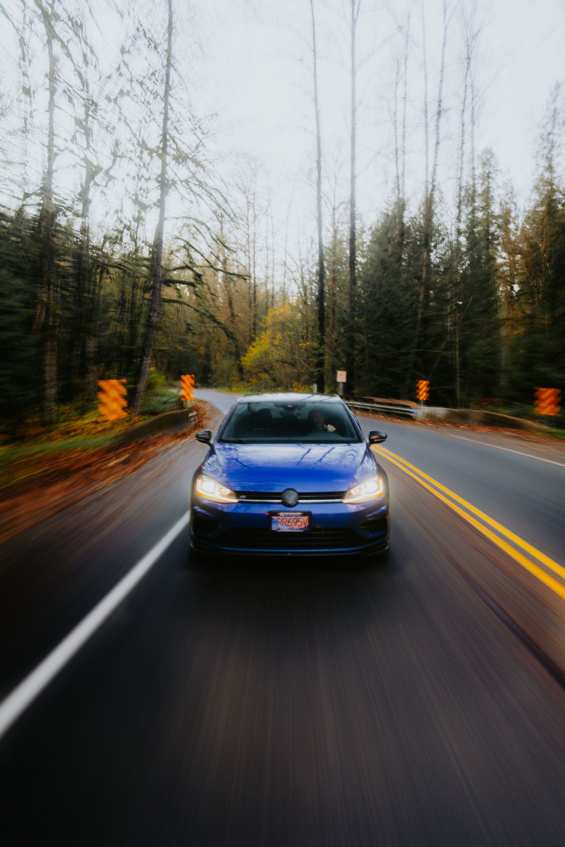 Blue car driving on a tree-lined Texas road, illustrating what happens if your SR-22 insurance lapse